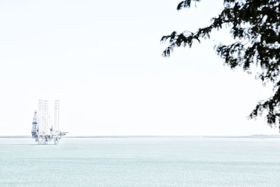 Sailboat in sea against clear sky