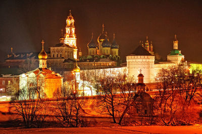 Illuminated buildings against sky at night