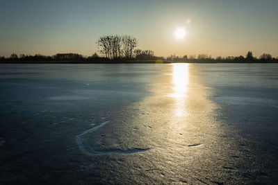 Frozen lake and the sun shining on the ice surface, eastern poland