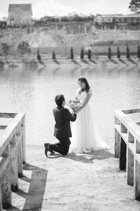 Man proposing woman at lake