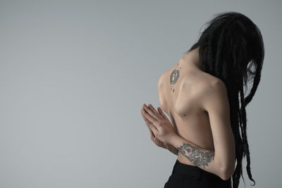Side view of woman standing against white background