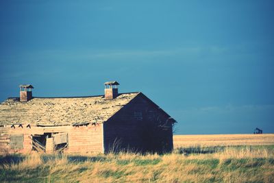 Abandoned house on field against sky