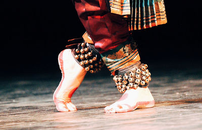 Low section of woman wearing anklet bells performing bharatanatyam dance