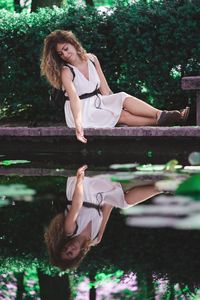 Portrait of young woman sitting near the water 