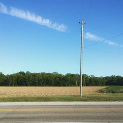 Trees on field against cloudy sky