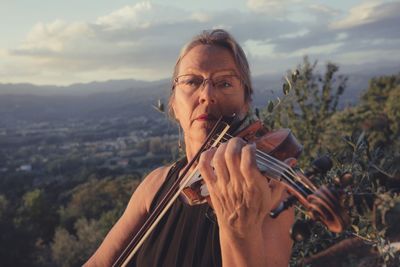 Portrait of mature woman playing violin