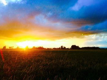 Scenic view of field against cloudy sky