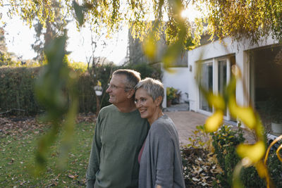 Happy senior couple in garden looking around