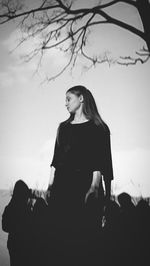 Thoughtful young woman standing against sky