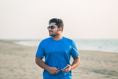 Portrait of young man standing at beach