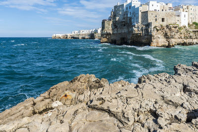 Scenic view of sea by buildings against sky