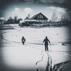 Rear view of people on snow covered field