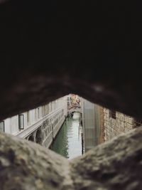 Bridge over river by buildings against sky at night