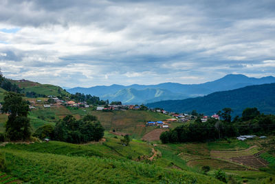 Scenic view of field and mountains against sky