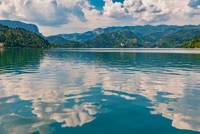 Scenic view of lake by mountains against sky