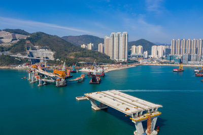 High angle view of sea and cityscape against sky