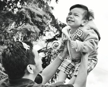 Happy father lifting son at park