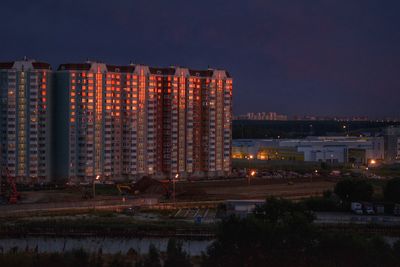 Illuminated cityscape against sky at night