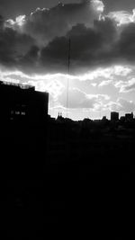 Silhouette of building against cloudy sky