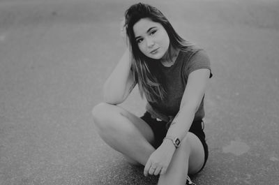 Portrait of young woman sitting outdoors