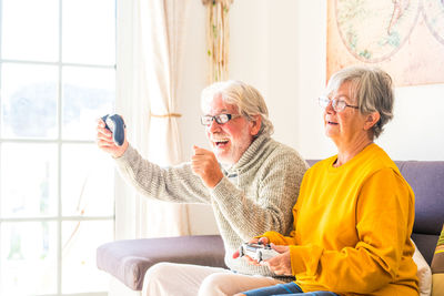 Senior couple playing video game at home