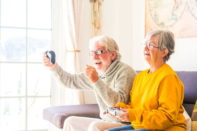 Man and woman using smart phone at home