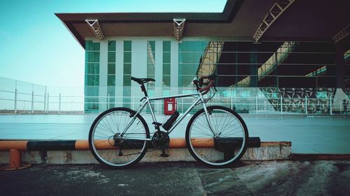 Bicycle parked on footpath by building