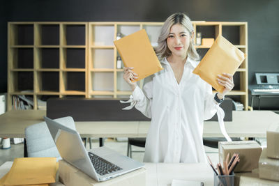 Portrait of businesswoman using laptop while sitting on table