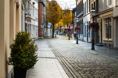 Sidewalk by buildings in city during autumn