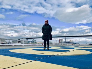 Full length of woman standing at promenade against sky