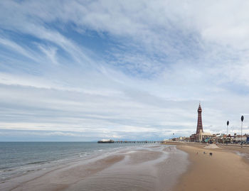 Scenic view of beach against cloudy sky