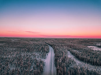 Scenic view of snow covered landscape against sky during sunset