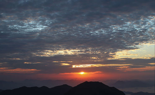 Scenic view of silhouette mountains against sky during sunset