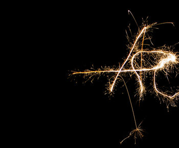 Close-up of illuminated firework display against sky at night
