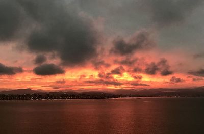 Scenic view of sea against dramatic sky during sunset
