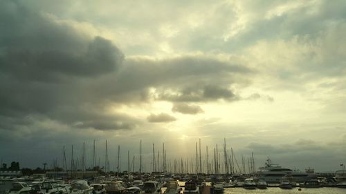 Sailboats in city against sky during sunset