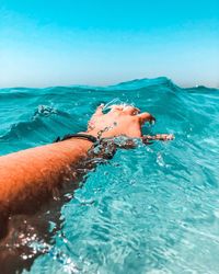 Woman swimming in pool by sea against sky