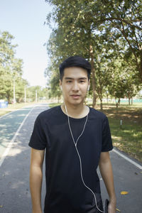 Portrait of young man standing on road