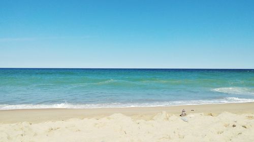 Scenic view of beach against clear blue sky