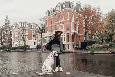 Woman with umbrella against canal