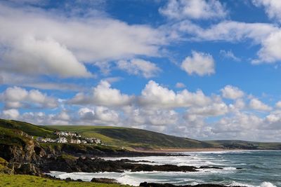 Scenic view of sea and mountains against cloudy sky