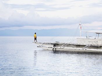 Man sailing on sea against sky