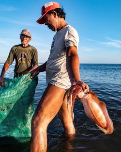 Midsection of man in sea against sky