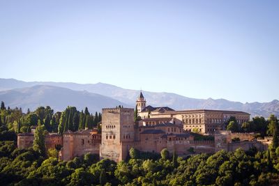 Alhambra palace by mountains against clear sky. andalucia, spain
