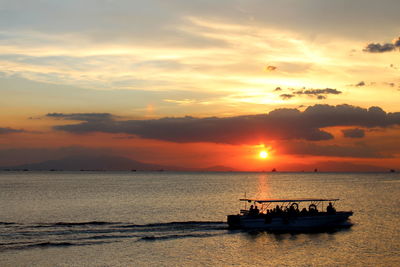 Tourists on boat in sea at dusk