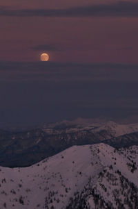 Scenic view of snowcapped mountains against sky at sunset