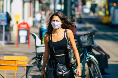 Full length portrait of young woman in city