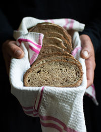 Midsection of person holding ice cream cone against black background