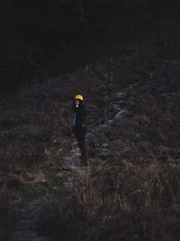 Full length of person walking on field in forest