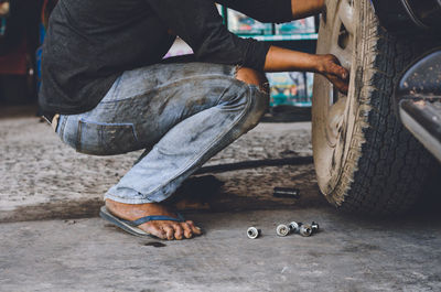 Low section of man standing by car